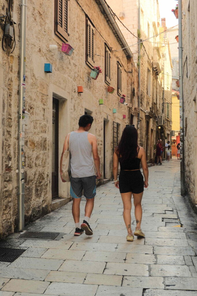 Travellers walking through a narrow old town street in Split, Croatia, near the tour pickup location.